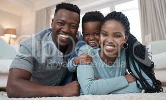 Our little one keeps us on our toes. a young couple lying on the living room floor and bonding with their son at home.