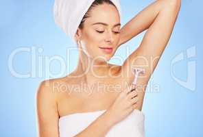 Quick and painless. a young woman shaving against a blue background.