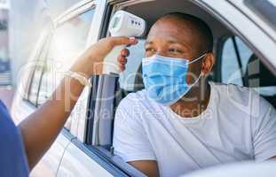 Covid, corona and infection testing site as a drive thru service station for people traveling. African man wearing a protective face mask to avoid infection and stop the spread while driving his car