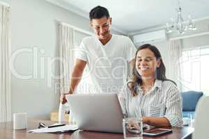 Time to work on our finances. a young couple using a laptop to their household budget in the living room at home.