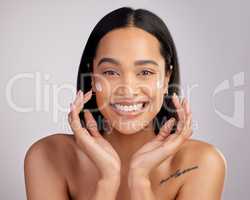 M skincare regime is definitely working. Studio portrait of an attractive young woman applying moisturizer to her face against a pink background.