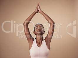 Connecting with my higher purpose. an attractive young woman standing alone in the studio and holding a meditative pose while practising yoga.