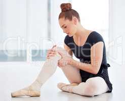 Trying to perfect the technique can be a pain. a young ballerina holding her leg in pain.