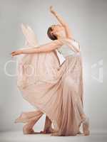 Feel her passion. Full length shot of an attractive young female ballet dancer in studio against a grey background.