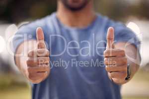 A double dose of positivity for you. an unrecognisable man showing thumbs up while standing outside at college.