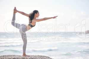 Yoga is a mirror to look at ourselves from within. a young woman practising yoga on the beach.
