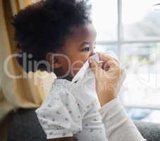 Mom always gives the best support. a little girl blowing her nose into a tissue at home.