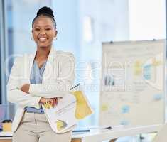 Always proud to present my ideas. a proud young businesswoman in her office holding a file of documents.