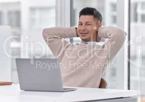 Guess who just finished his final deadline. Portrait of a young businessman sitting with his hands behind his head while working on a laptop in an office.