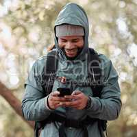 Im getting some friends to join me on my hike. a man using his cellphone while out on a hike.