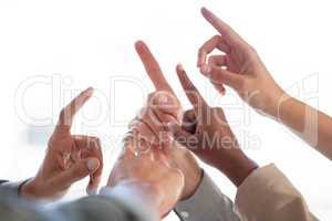A decision to stop division. a group of unrecognizable businesspeople joining their fingers up against a white background.