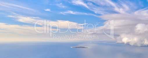 Beautiful, calm and quiet view of the ocean and clouds in blue sky with a small island and copy space background. Landscape of a cloudy atmosphere and climate in a natural environment during the day