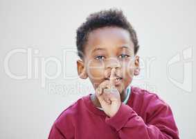 I hope you can keep a secret because I can. an adorable little boy standing against a white background.