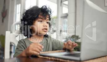 Im sure I can solve this. an adorable little boy using a laptop while sitting at home.