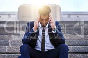 Give me a minute I need to think. a young businessman experiencing a migraine.