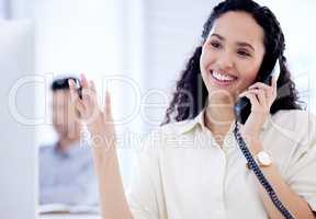 Selling is her strong point. a young businesswoman talking on a telephone while working in an office.