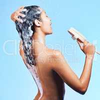 I am in constant awe of my own presence. a beautiful young woman enjoying a singing session during her shower agains a blue background.