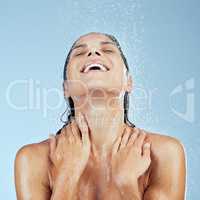 Its shower hour. Studio shot of an attractive young woman taking a shower against a blue background.