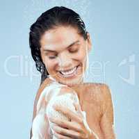 Perfect pampering time. Studio shot of an attractive young woman taking a shower against a blue background.