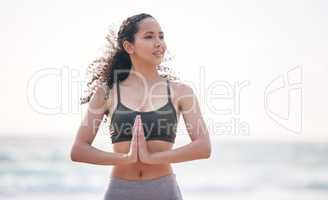 Ive got 99 problems but with yoga I forget them all. a young woman practising yoga on the beach.