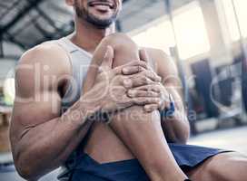 Hold this stretch to loosen up your muscles. Closeup shot of an unrecognisable man stretching his legs while exercising in a gym.
