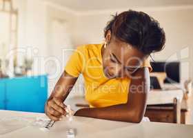 Testing for virus, disease and illness during covid pandemic at home. One serious, anxious and black female using a self medical test kit to check for sickness on a table or counter alone at home