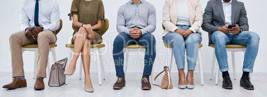 Waiting their turn at a new opportunity. Studio shot of a group of businesspeople sitting in line against a white background.