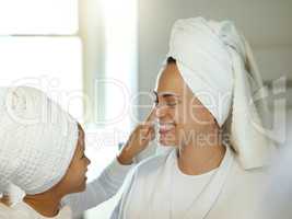 Skincare, face and playful mother and daughter applying lotion together. Adorable little girl and mom doing a facial using moisturizer or cream. Parent and child enjoying beauty skin cleanse at home