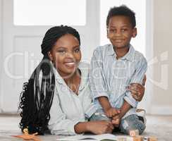 Supervising homework and playtime. Portrait of a mother bonding with her son at home.