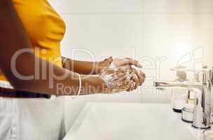 Woman washing, cleaning and rubbing hands with soap and water for good personal hygiene, safety and health in a bathroom at home. Killing germs, virus and bacteria to prevent the spread of infection