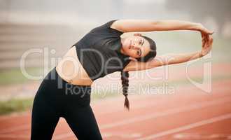 We have the ability to create change and inspire people. an athletic young woman stretching while out on the track.