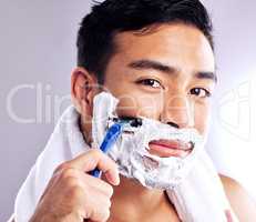 Shaving has been around since the cave man. a handsome young man shaving his facial hair.