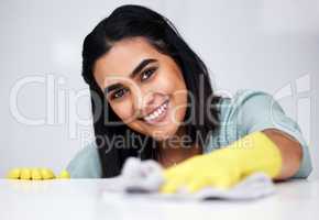 Achieving a spotless home one wipe at a time. a woman using a cloth while wiping a white counter.