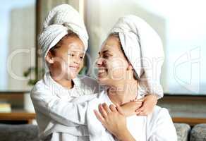 Happy, smiling and relaxed mother and daughter spa day at home with face masks for healthy skincare and personal hygiene. Cute little girl and parent bonding and enjoying a pamper treatment together