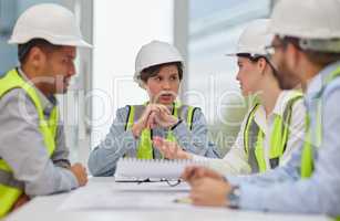 Planning it all out. a group of young construction workers sitting around the boardroom table during a meeting.