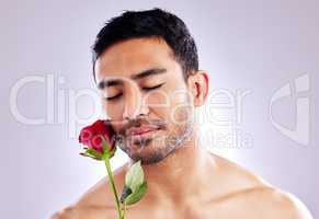 Handle yourself with care. Studio shot of a handsome young man posing with a red rose.