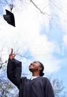 Another goal ticked off her list. a young woman throwing her hat in the air on graduation day.