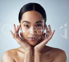 My skin needs its daily dose of love. Studio portrait of an attractive young woman applying moisturizer against a grey background.