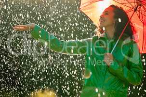 Enjoy every moment of life down to the last drop. a beautiful young woman having fun in the rain.