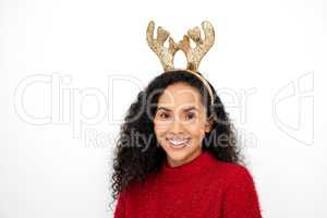 I hope I can cheer you up. Studio shot of a young woman wearing a reindeer antlers headband against a white background.
