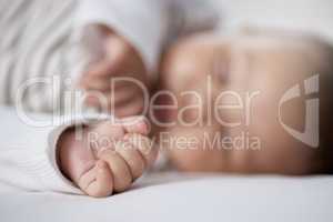 Babies need lots of sleep to grow. Closeup shot of a babys hand while asleep at home.
