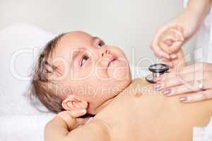 Mom help me please. a little baby having its chest checked by a female doctor.