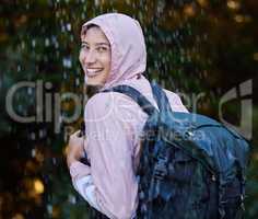 This hike isnt cancelled just because of some rain. an attractive young woman standing alone outside in the rain.