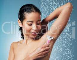 Just my weekly grooming session. an attractive young woman using a shaving stick to shave her underarms during her shower.
