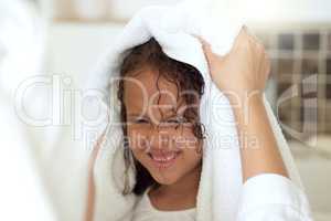 Haircare routine, cleaning and hair being washed by a mother for her happy, carefree and smiling daughter at home. Loving, caring and kind parent helping her child get dressed, get dry or get clean