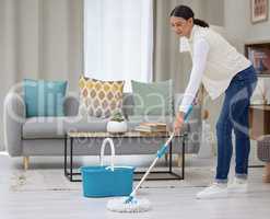 No scuff marks on this floor. a young woman mopping her living room floors.