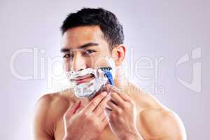 How often do you groom your facial hair. a handsome young man shaving his facial hair.