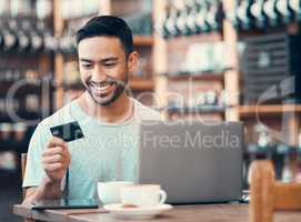 Man doing online shopping, purchase or loan with credit card and laptop at an Internet cafe. Young happy male paying off insurance debt on a digital banking app with modern tech and looking satisfied