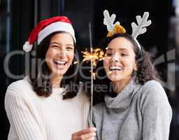 Christmas is the day that holds all time together. two friends using a sparkle stick ay home.