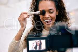 Exactly like this. a young woman doing her makeup while recording a video for her blog.